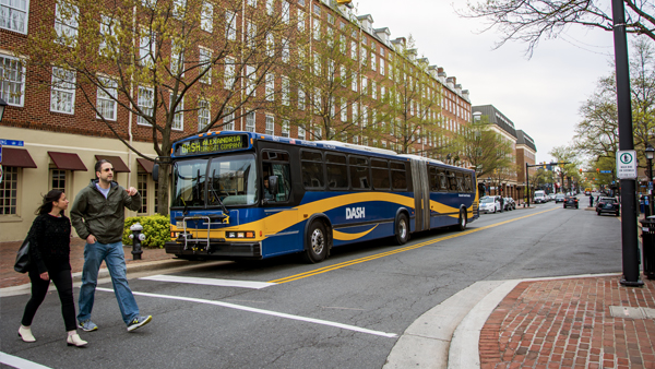Pedestrians cross in crosswalk in front of DASH bus in Alexandria, Virginia.