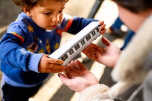 Children handed toy replica of San Francisco BART train car.