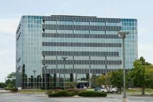 High-rise office building with parking and landscaping in foreground.